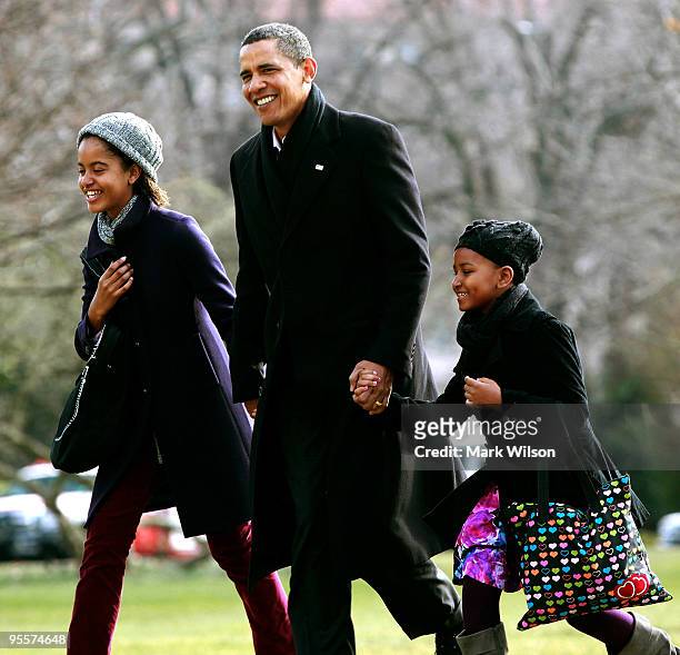 President Barack Obama walks with his daughters Malia and Sasha after they arrive on the South Lawn of the White House on January 4, 2010 in...