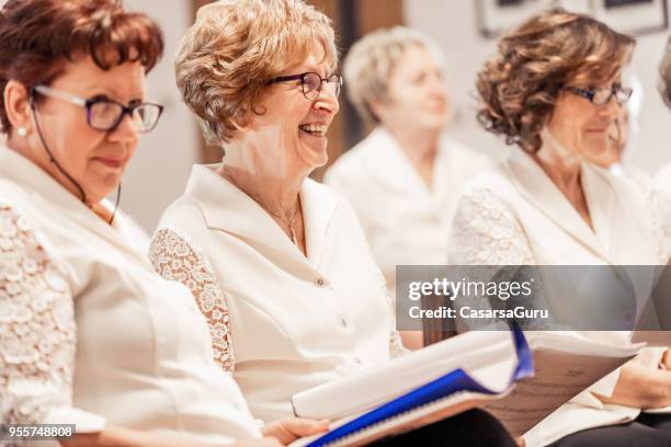 senior women smiling at choir practice - music rehearsal stock pictures, royalty-free photos & images