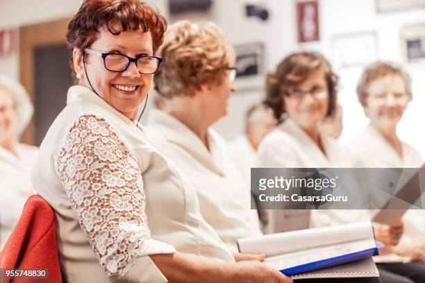 senior woman smiling at choir practice - music rehearsal stock pictures, royalty-free photos & images