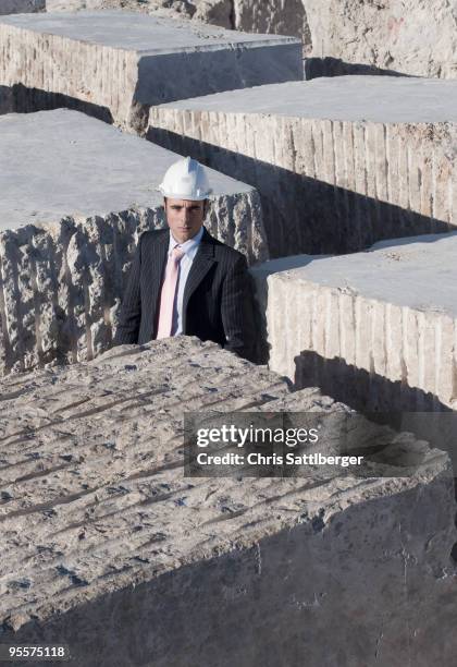 bsuinessman standing in labyrinth of marble blocks - chris sattlberger stock pictures, royalty-free photos & images