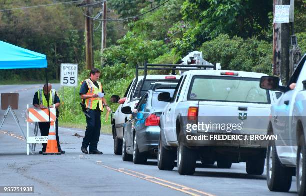 Police check the identity of returning evacuees to Leilani Estates near the town of Pahoa on Hawaii's Big Island on May 7 after the residents were...