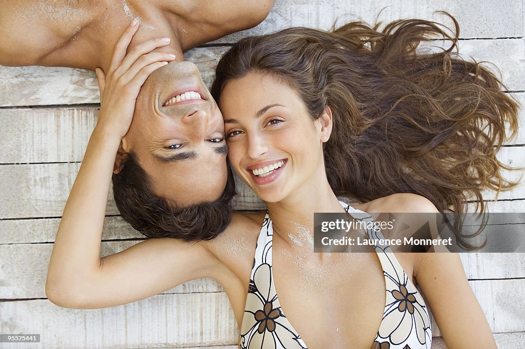 Smiling couple laying down heads inverted