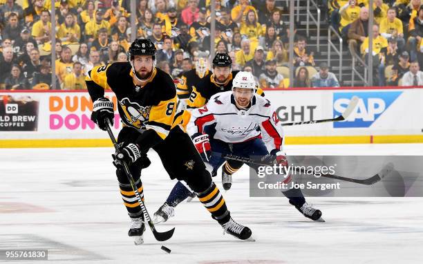 Brian Dumoulin of the Pittsburgh Penguins handles the puck against Evgeny Kuznetsov of the Washington Capitals in Game Six of the Eastern Conference...