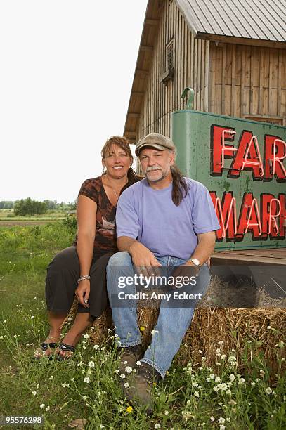 farmer couple seated by barn - brainerd stock-fotos und bilder