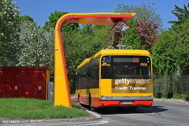 modern electric bus on the charging station - warsaw bus stock pictures, royalty-free photos & images