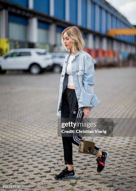 Lisa Hahnbueck wearing light blue Off White jeans jacket, Gina Tricot cropped top, black Adidas track pants, nike paper max x off white sneaker,...