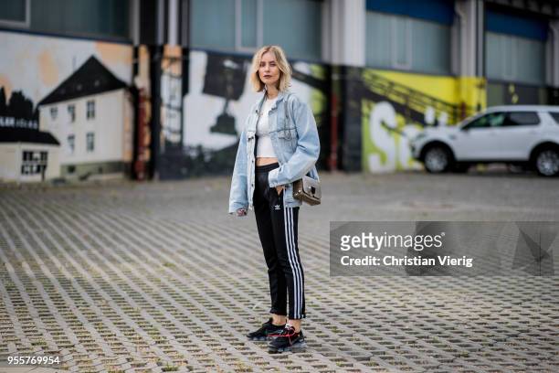 Lisa Hahnbueck wearing light blue Off White jeans jacket, Gina Tricot cropped top, black Adidas track pants, nike paper max x off white sneaker,...