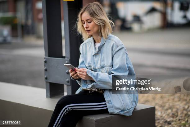 Lisa Hahnbueck wearing light blue Off White jeans jacket, Gina Tricot cropped top, black Adidas track pants, nike paper max x off white sneaker,...