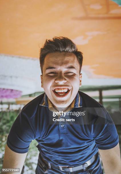 portrait of happy young man hanging upside down in playground - upside down stock pictures, royalty-free photos & images