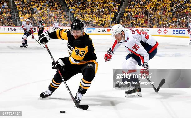 Conor Sheary of the Pittsburgh Penguins handles the puck against Alex Chiasson of the Washington Capitals in Game Six of the Eastern Conference...