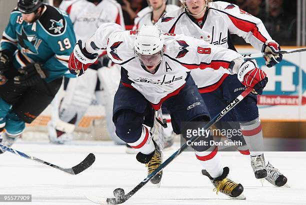 Alex Ovechkin of the Wahington Capitals maneuvers the puck down the ice with Joe Thornton of the San Jose Sharks coming up from behind him during an...