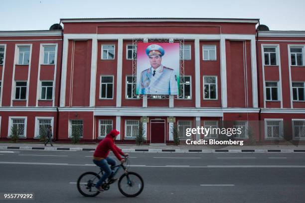 Cyclist rides past a banner featuring an image of Tajikistan President Emomali Rahmon displayed on a building in Dushanbe, Tajikistan, on Sunday,...