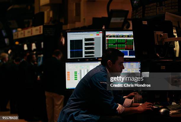 Financial professional works at his station on the floor of the New York Stock Exchange near the end of the trading day on January 4, 2010 in New...