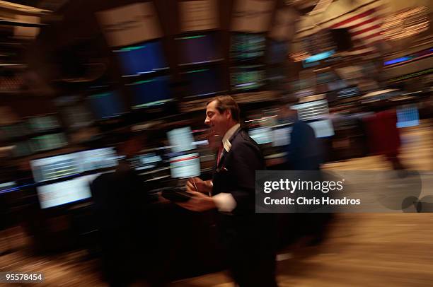 Financial professional walks past on the floor of the New York Stock Exchange near the end of the trading day on January 4, 2010 in New York City....