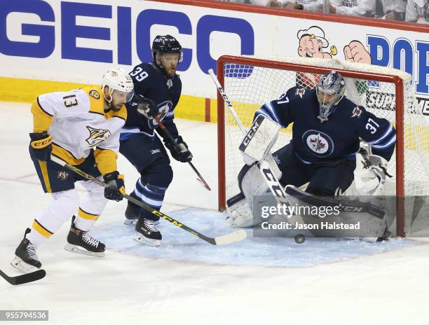 Connor Hellebuyck of the Winnipeg Jets makes a save off Nick Bonino of the Nashville Predators in Game Six of the Western Conference Second Round...