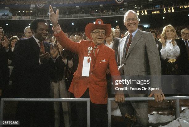 St Louis Cardinal owner Gussie Busch waving to the crowd standing next to Baseball commissioner Bowie Kuhn and singer Lou Rawls before a 1982 world...