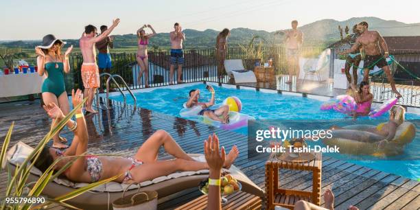 jóvenes tener fiesta en la piscina - fiesta de piscina fotografías e imágenes de stock