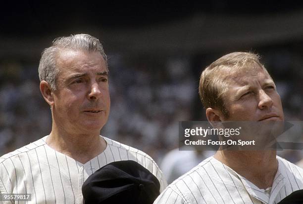 S: Outfielder Mickey Mantle formally of the New York Yankees stands with ex teammate Joe DiMaggio for the National Anthem before a circa 1970's Old...