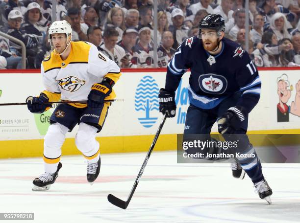 Kyle Turris of the Nashville Predators and Adam Lowry of the Winnipeg Jets follow the play down the ice during first period action in Game Six of the...