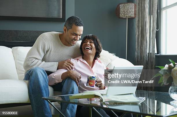 african couple laughing and looking at laptop - 40 2009 stock pictures, royalty-free photos & images