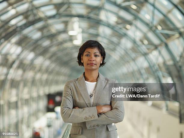 african businesswoman standing with arms crossed - woman in black suit stock pictures, royalty-free photos & images