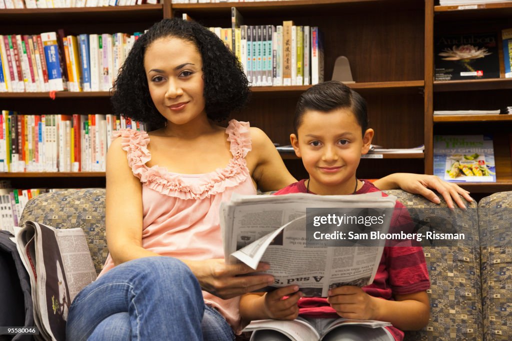 Mother and son reading newspapers in libraries