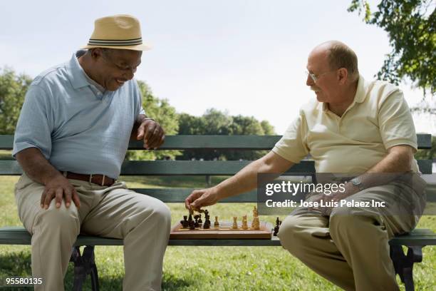 men playing chess on park bench - west new york new jersey stock-fotos und bilder