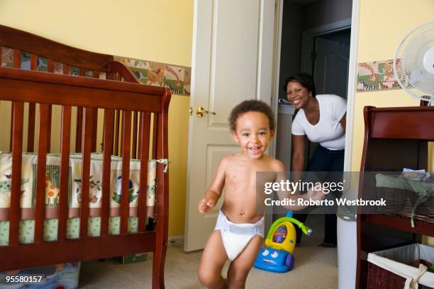 african mother chasing young son - niño corriendo en pañales fotografías e imágenes de stock