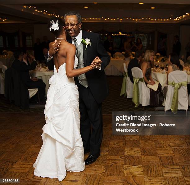 African bride and father dancing at wedding reception