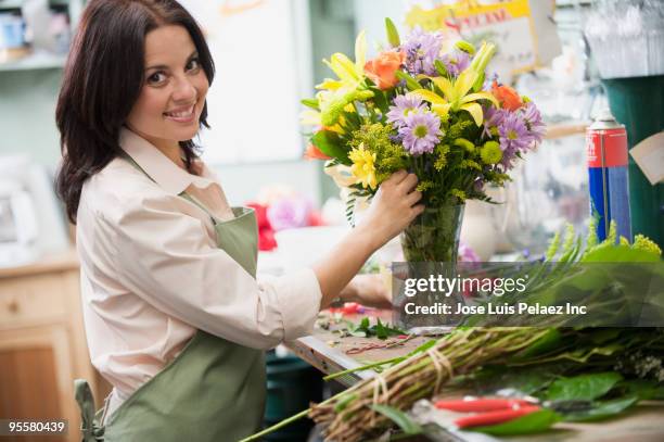 hispanic woman working in florist shop - florist arranging stock pictures, royalty-free photos & images