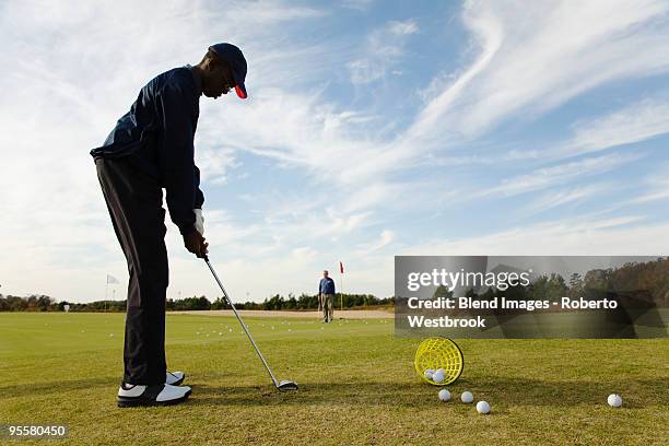 african boy practicing putting on golf course - young golfer stock pictures, royalty-free photos & images