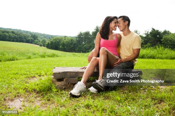 hispanic woman sitting on rock in field - asian pin up girls stock-fotos und bilder