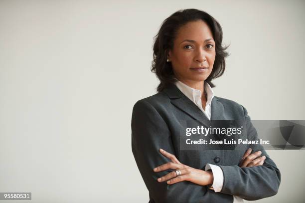 mixed race businesswoman with arms crossed - women in suits stock pictures, royalty-free photos & images