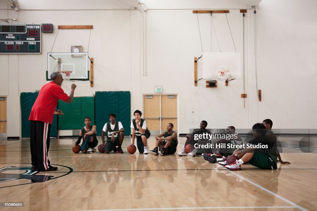 Coach meeting with basketball team in gym