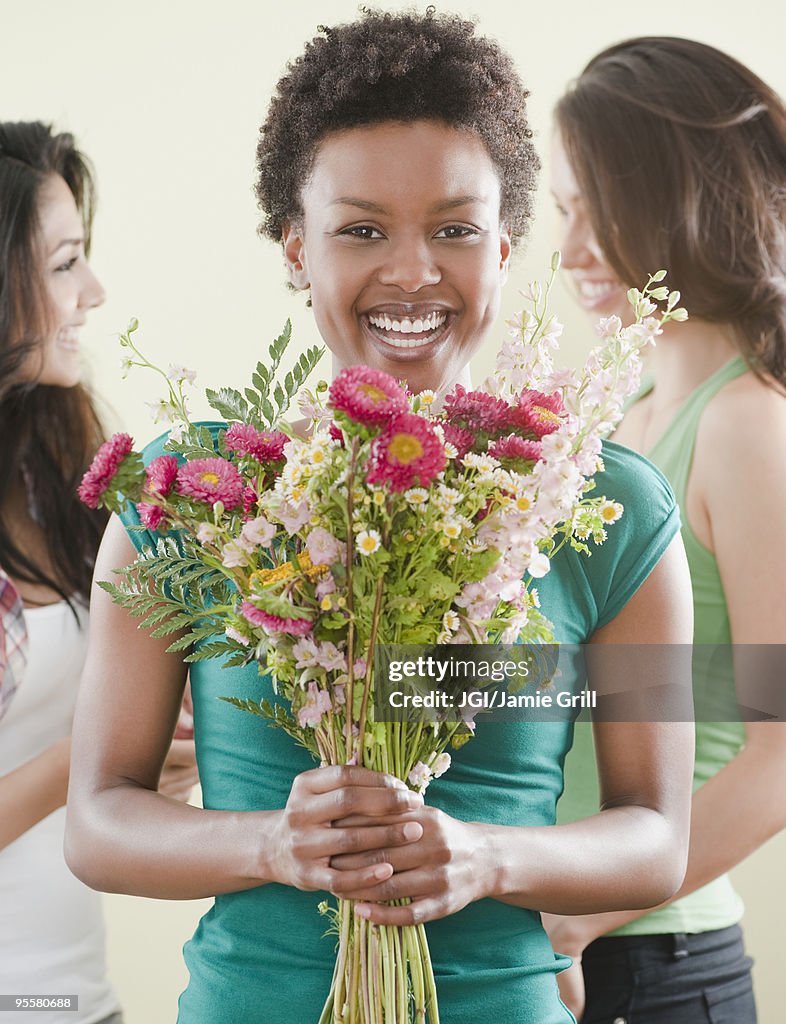 African woman holding bouquet of flowers