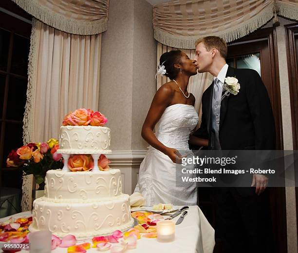 bride and groom kissing next to wedding cake - reston stock pictures, royalty-free photos & images
