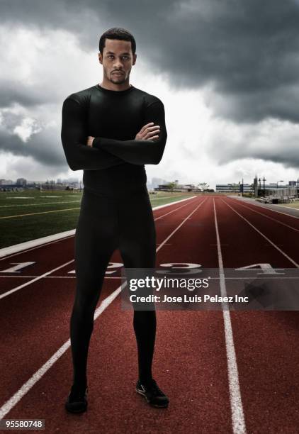 serious mixed race athlete with arms crossed on running track - determination athlete stock pictures, royalty-free photos & images