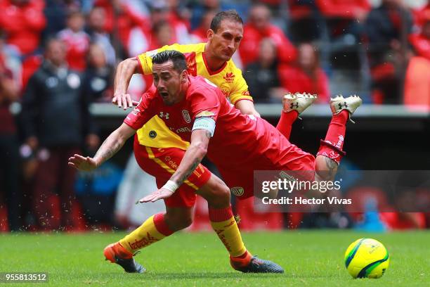 Emanuel Loeschbor of Morelia struggles for the ball with Rubens Sambueza of Toluca during the quarter finals second leg match between Toluca and...