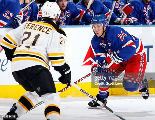 Ryan Callahan of the New York Rangers skates for the puck under pressure by Andrew Ference of the Boston Bruins on January 4, 2010 at Madison Square...