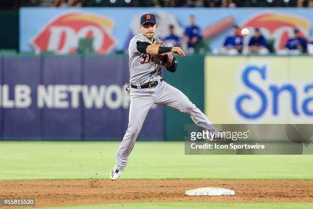 Detroit Tigers shortstop Jose Iglesias fumbles the baseball and makes an errant throw to first base during the game between the Texas Rangers and the...