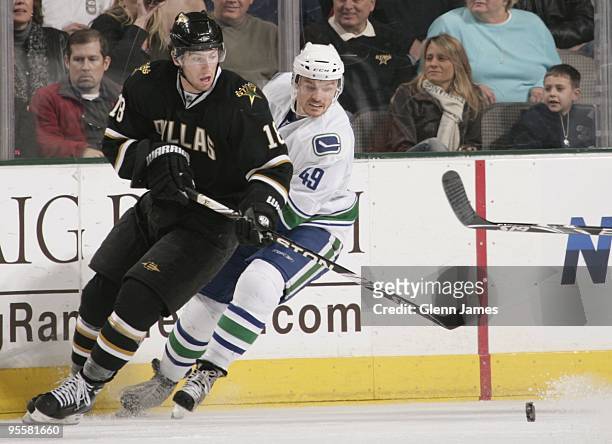 James Neal of the Dallas Stars tries to get to the loose puck against Alexandre Bolduc of the Vancouver Canucks on January 2, 2010 at the American...