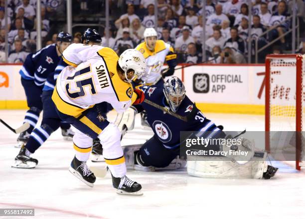 Goaltender Connor Hellebuyck of the Winnipeg Jets makes a glove save on Craig Smith of the Nashville Predators during second period action in Game...