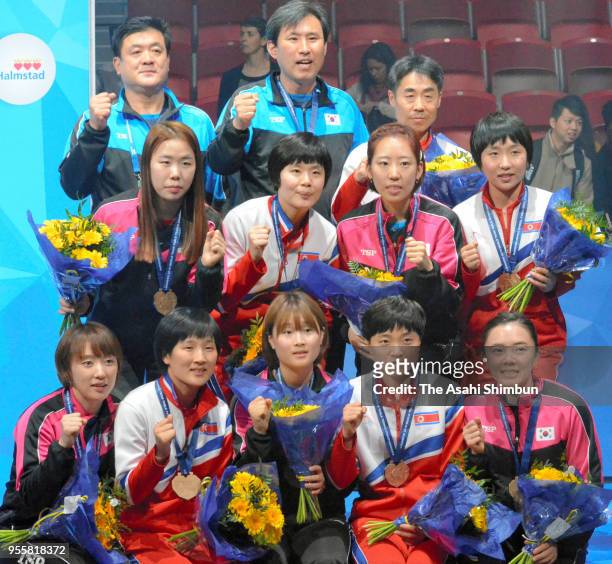 Corea players and coaches pose for photographs during the medal ceremony for the Women's event on day seven of the World Team Table Tennis...