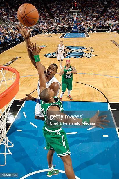 Dwight Howard of the Orlando Magic hooks a shot over Shelden Williams of the Boston Celtics during the game on December 25, 2009 at Amway Arena in...