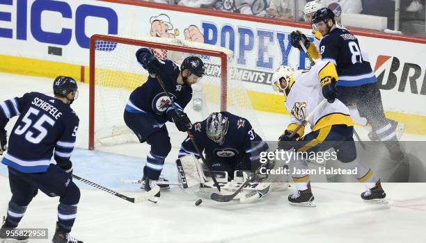 Connor Hellebuyck of the Winnipeg Jets makes a save against Colton Sissons of the Nashville Predators in Game Six of the Western Conference Second...