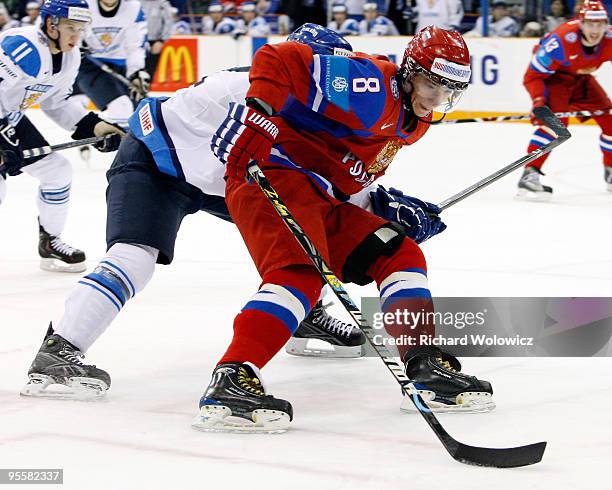 Alexander Burmistrov of Team Russia skates with the puck while being defended by Aleksi Laakso of Team Finland during the 2010 IIHF World Junior...