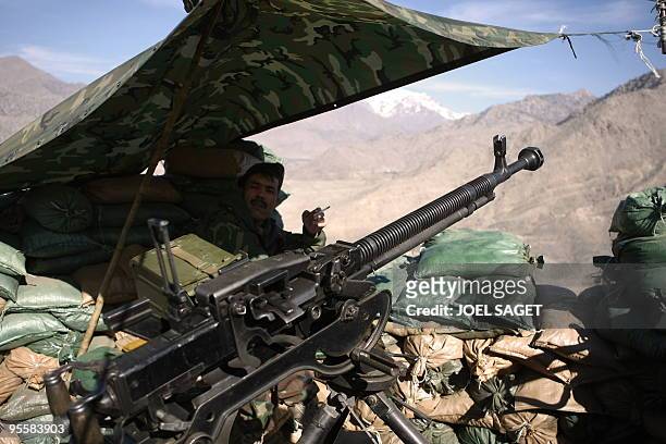 An Afghan soldier is seen with a Russian-made 12.7mm calibre machine gun at the OMLT of the Kandak 32 "Eagle's Nest" observation post in the Alah Say...