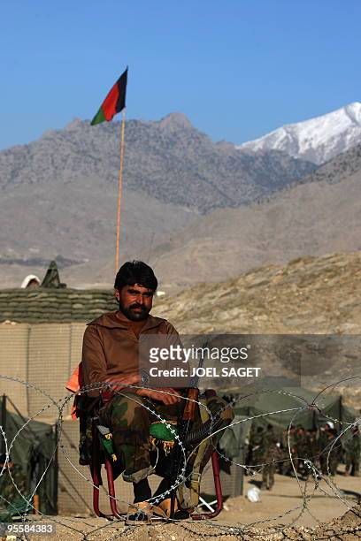 An Afghan National Army soldier from the OMLT of the Kandak 32 is seen on sentry duty at a combat outpost in the Alah Say valley in Kapisa province...