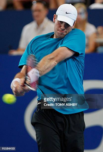 John Isner of the US returns a shot against Lleyton Hewitt of Australia during their singles match on the fifth session, day four of the Hopman Cup...