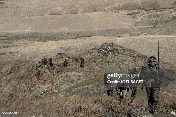 French soldiers from the OMLT of the Kandak 32 walk down a hill from an "Eagle's Nest" observation post in the Alah Say valley in Kapisa province on...